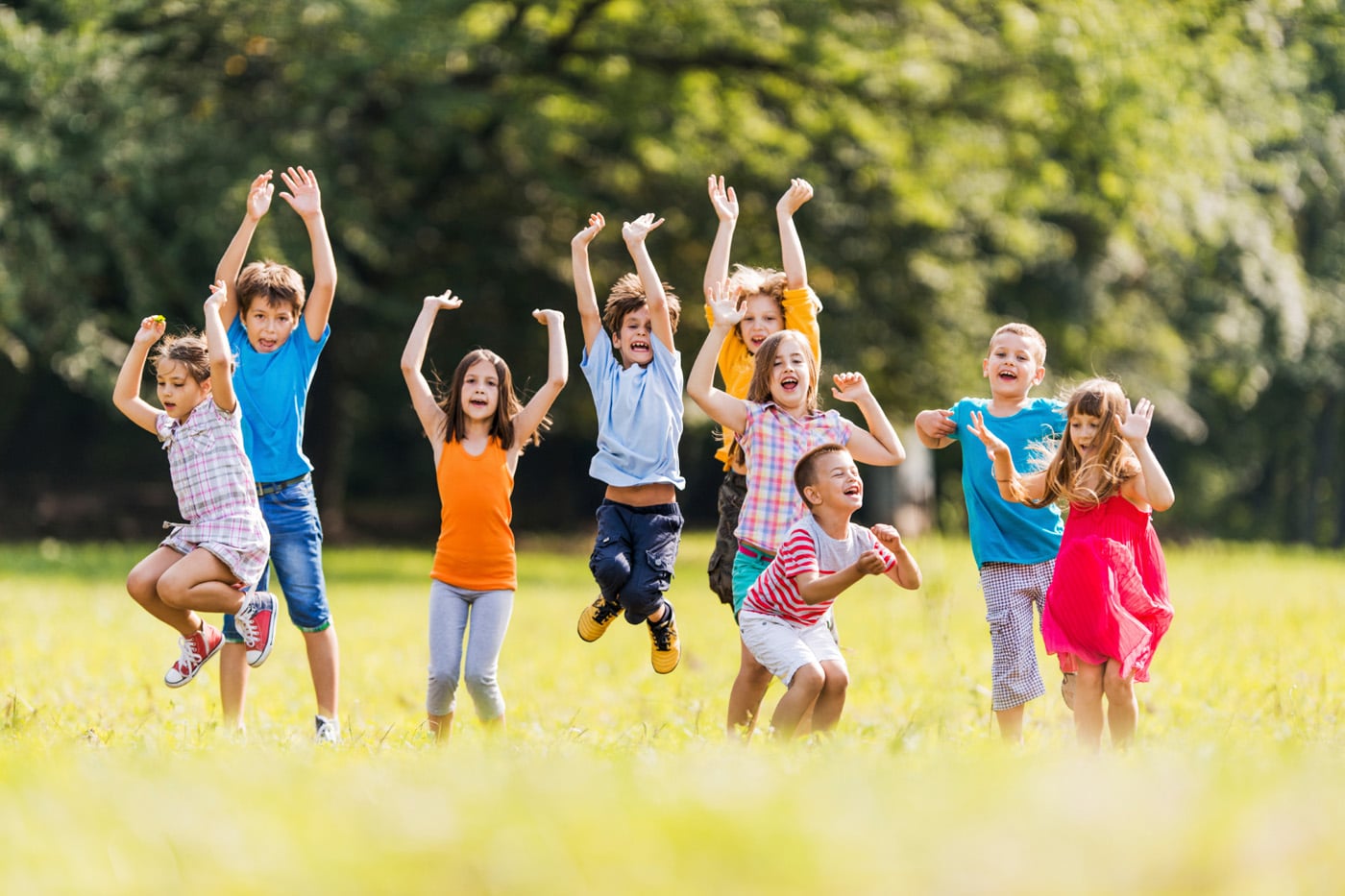 Large group of children jumping in the park and having fun.