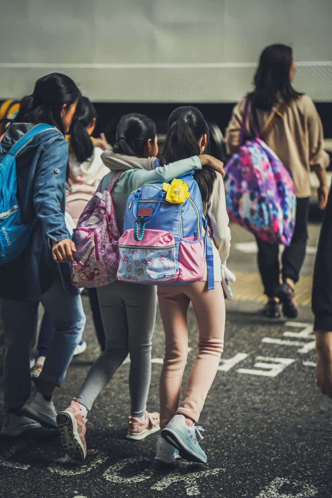 woman in blue jacket carrying pink backpack