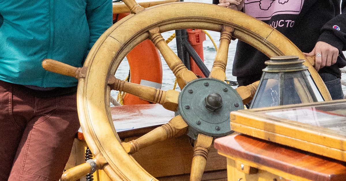 image of 2 people with a ships wheel