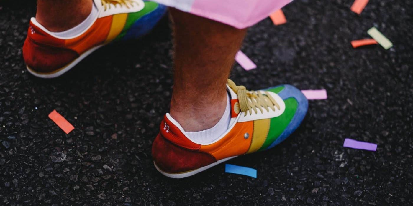 person wearing multicolored low-top shoes standing on ground