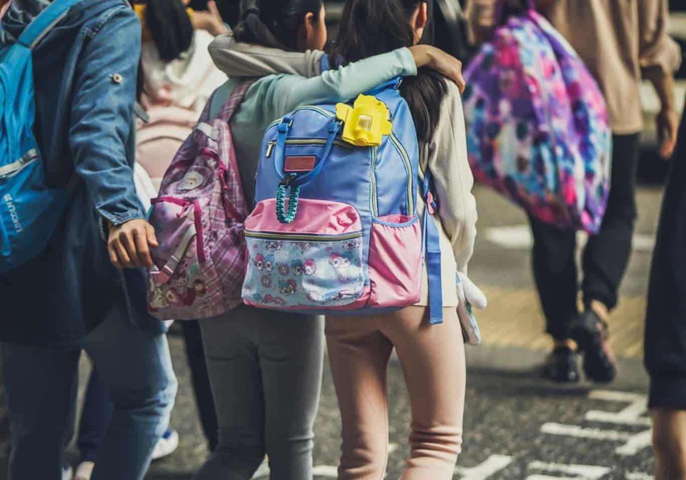 woman in blue jacket carrying pink backpack