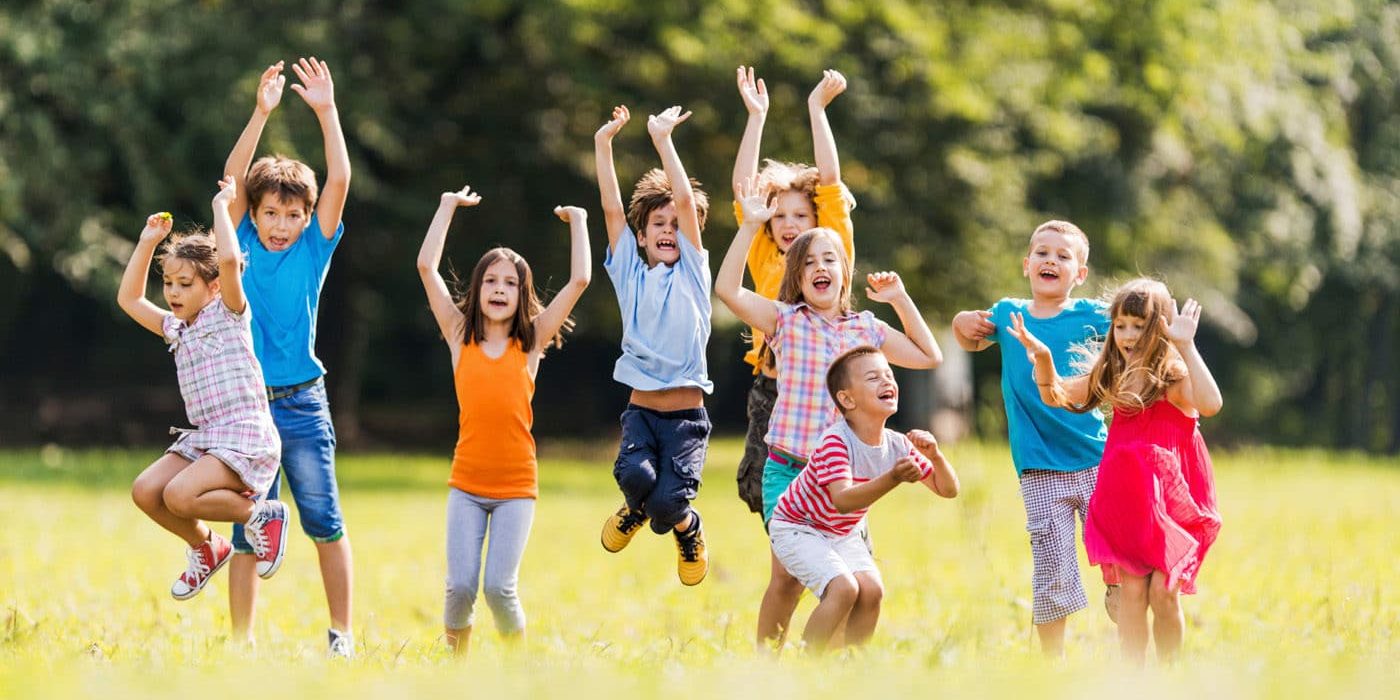 Large group of children jumping in the park and having fun.